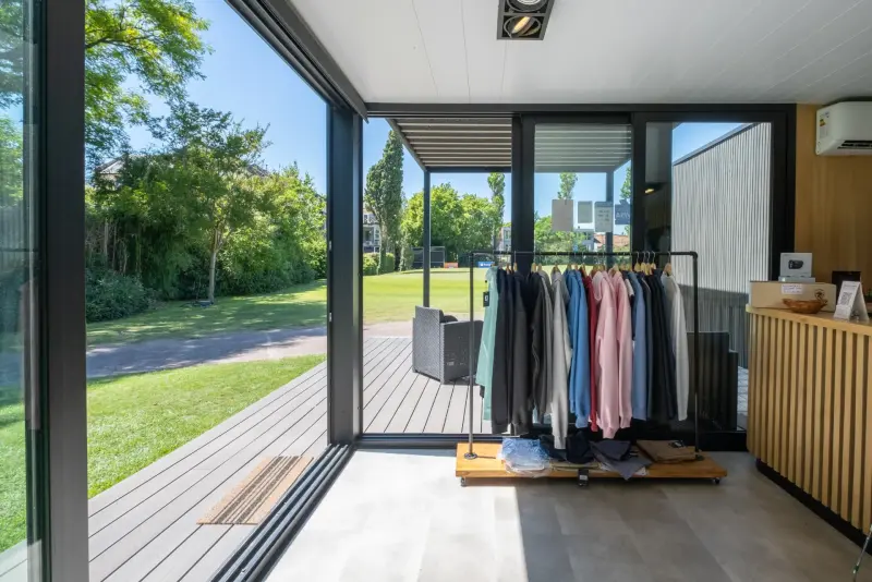 Interior del proshop con ropa exhibida y ventanales